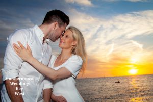 Wedding couples kisses at sunset on Smathers Beach in Key West, Florida