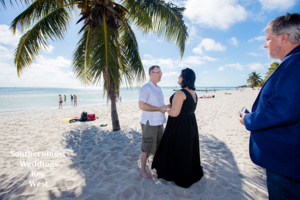 Wedding couple getting married under a palm tree on Smathers Beach in Key West, Florida