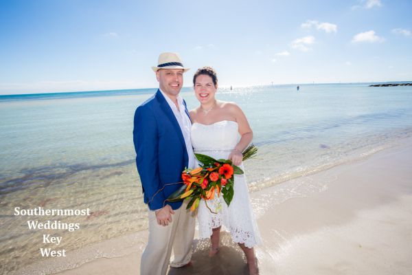 Wedding couple poses next to the ocean on Smathers Beach in Key West, Florida