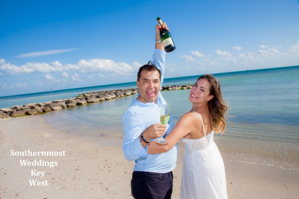 Wedding couple celebrate their wedding with a champagne toast on Smathers Beach