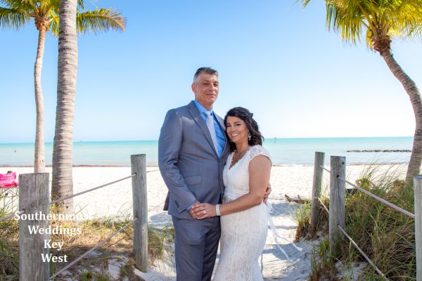 Wedding couple poses for photos on Smathers Beach in Key West, FL.