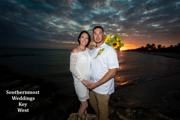 Wedding couple pose infront of the setting sun on Smathers Beach in Key West, Florida