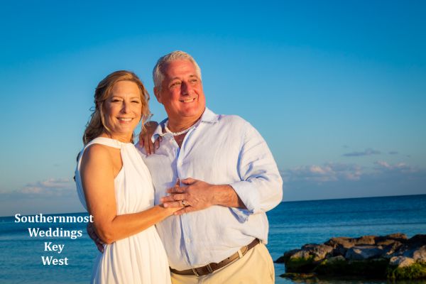 Wedding couple poses next to the ocean on Smathers Beach in Key West, Florida