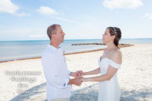 Wedding couple celebrate their wedding on Smathers Beach in Key West, Florida after getting married.