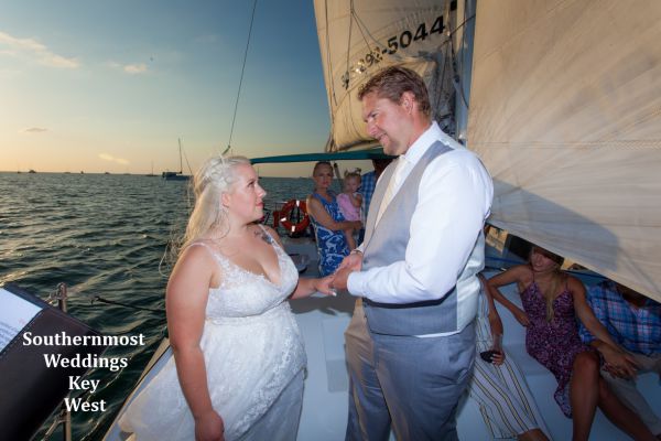 Wedding couple exchange vows during their private sunset sailboat wedding by Southernmost Weddings