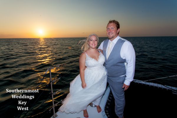 Wedding couple pose for photos by Southernmost Weddings with the sunset in the background