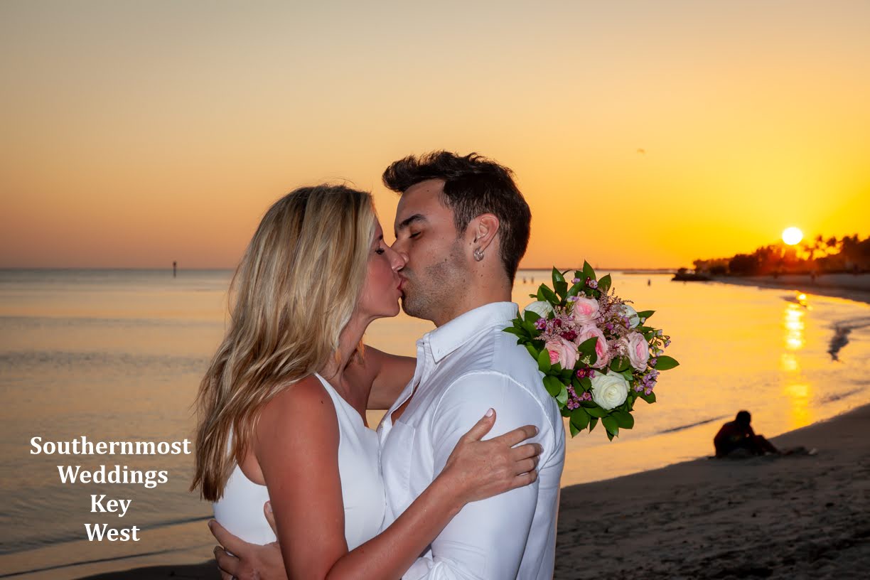Couple Kissing on the beach after their wedding with sunset in the background by Southernmost Weddings