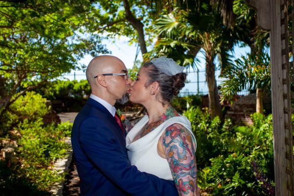 Wedding couple kiss in a historic tropical garden after their wedding planned by Southernmost Weddings Key West