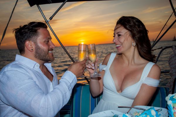 Bride & Groom celebrate their new life together with a glass of champange on their private sunset sailboat wedding planned by Southernmost Weddings