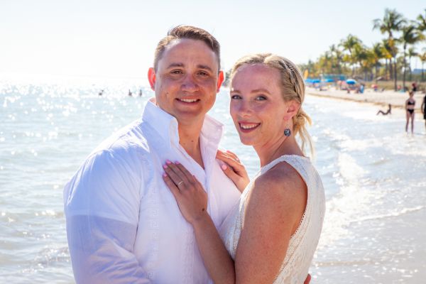 Bride & Groom pose for photos next to the ocean following their romantic beach elopement planned by Southernmost Weddings