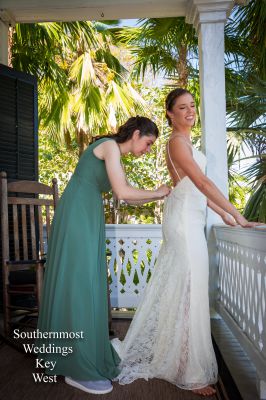 Bridesmaid helps her bride get ready before the wedding - Image by Southernmost Weddings Key West